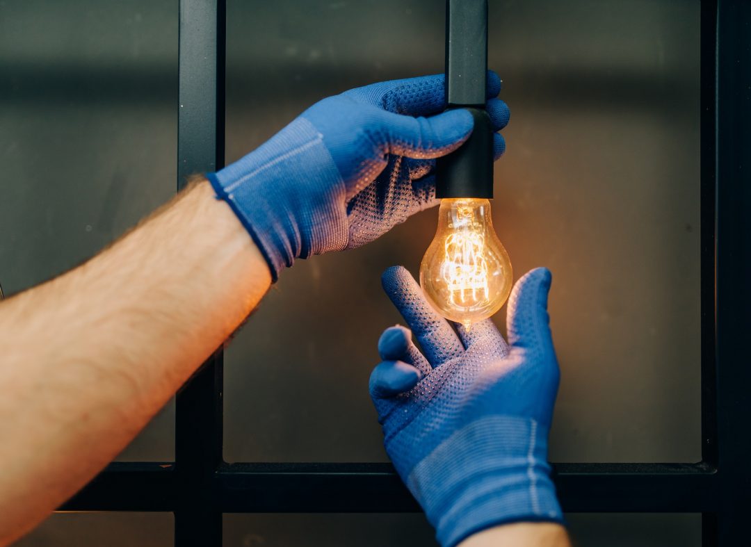 electrician changes the light bulb handyman.jpg